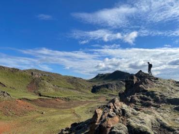 A person standing on a rocky hill