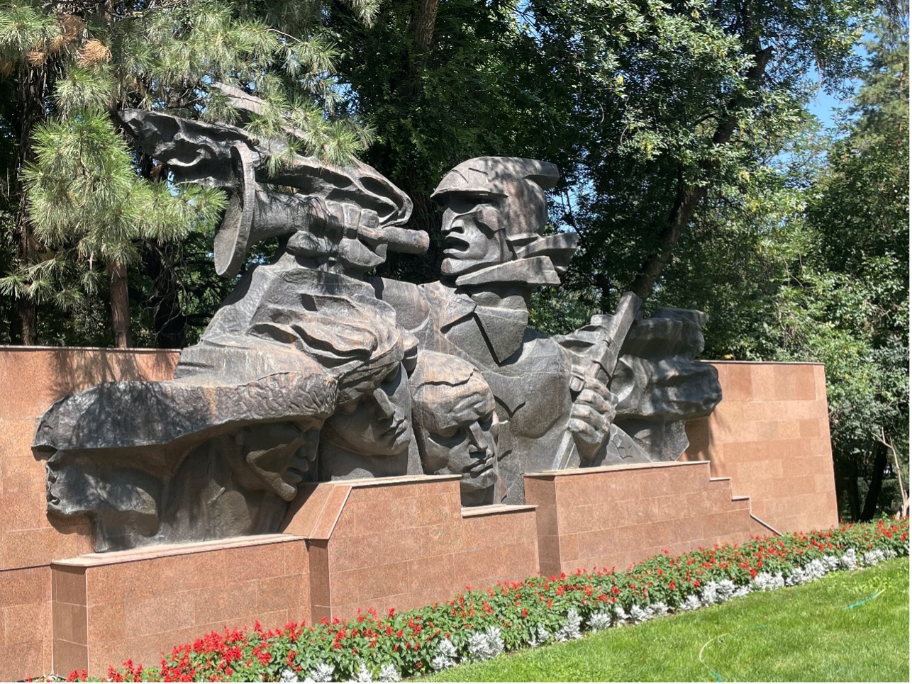 A picture of a stone statue of multiple warrior heads with swords