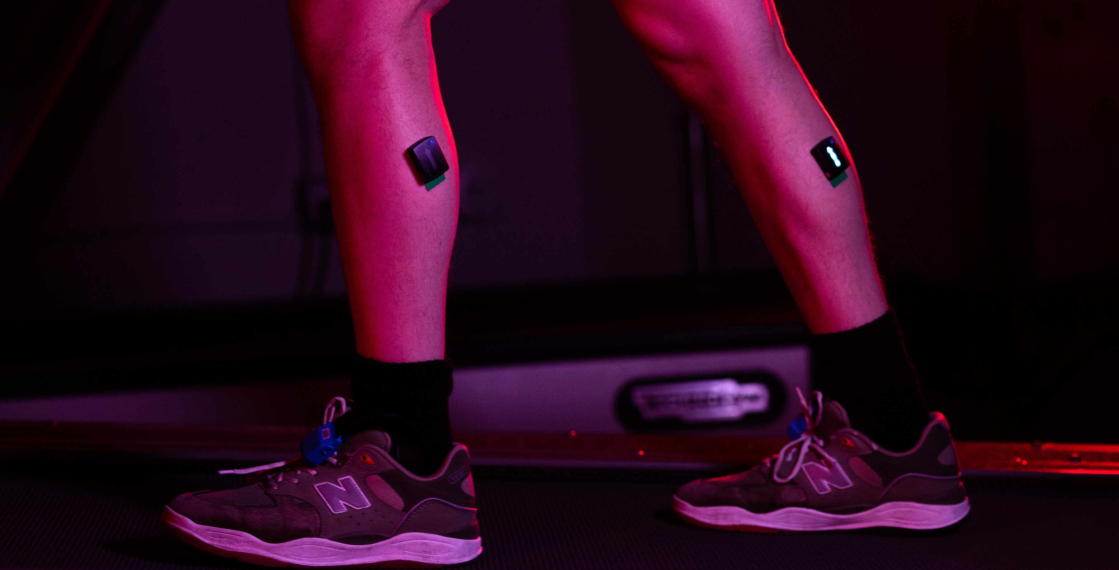 Person's legs with monitors attached while walking on treadmill