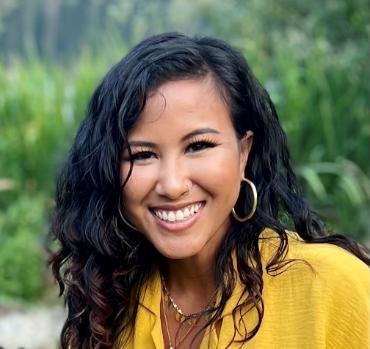 A smiling woman in a yellow shirt.