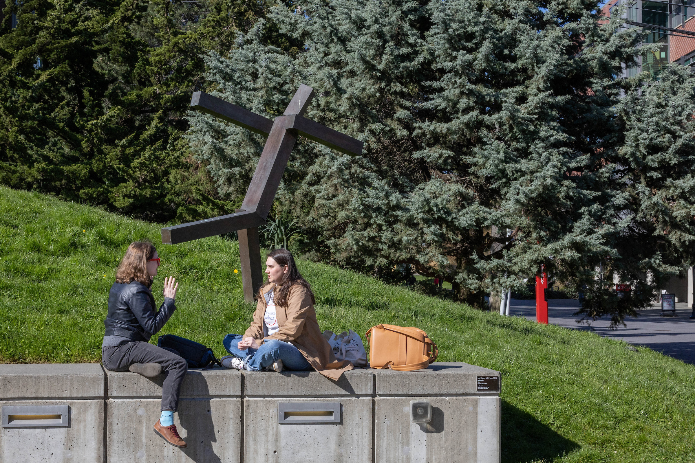 two students sitting outside the library lawn